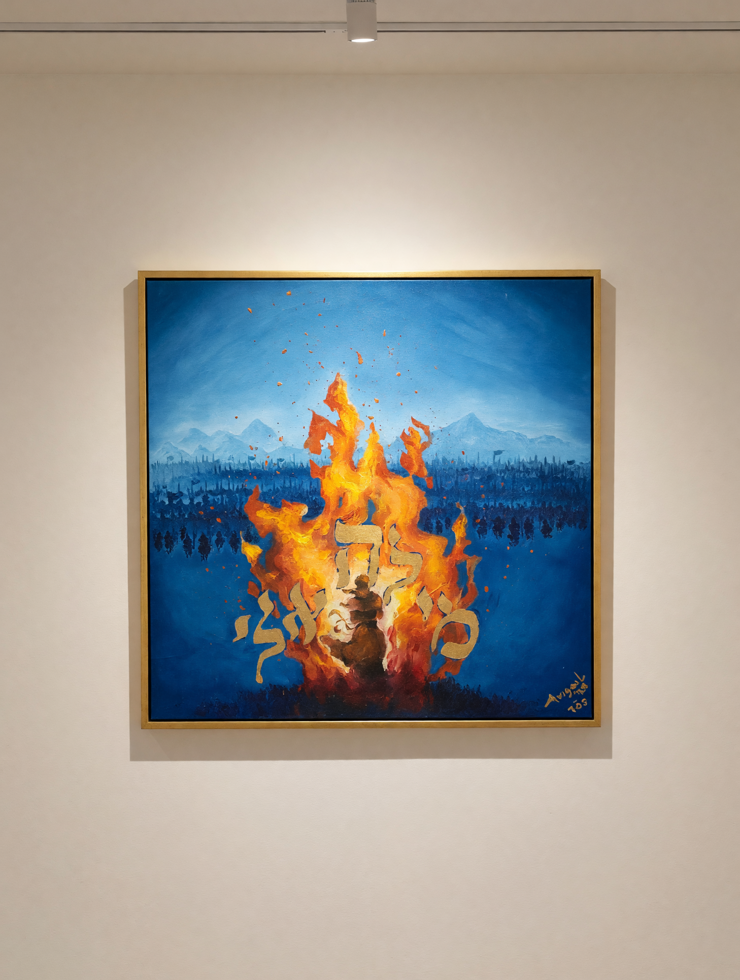 Framed oil painting of a radiant golden sunburst with Hebrew lettering and a figure in its glow against a deep blue mountain scene, signed Avigail and displayed in full on a white gallery wall under a spotlight